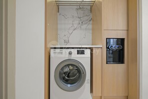 Eine kompakte Waschmaschine mit Bedienfeld und Wasserspender.