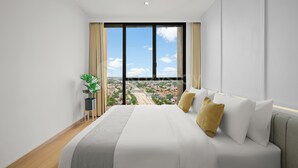 A modern hotel room with a large bed, a view of the cityscape, and a potted plant. - Brunn by Kozystay - Cilandak (South Jakarta)