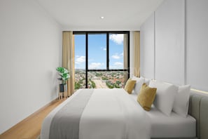 Ein modernes Hotelzimmer mit einem großen Bett, Blick auf die Stadtlandschaft und einer Zimmerpflanze.