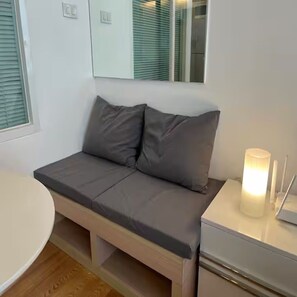 A modern bedroom with a sofa bed, bedside table, and a lamp. - Cozy Private Home - Steps to BTS & MRT Sukhumvit (Krung Thep Maha Nakhon)