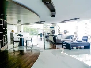 A modern interior with a dining area, seating, and a kitchen in the background. - Cozy Private Home - Steps to BTS & MRT Sukhumvit (Krung Thep Maha Nakhon)