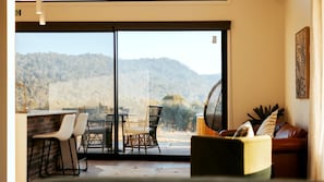 A room with a sliding glass door leading to a balcony with a mountain view.