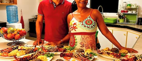 Un comptoir de cuisine sur lequel on trouve différents plats, notamment des fruits de mer et des légumes.
