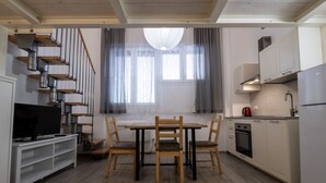 A modern kitchen with a dining table, chairs, a TV, and built-in appliances. - Caduti di Via Fani by Wonderful Italy (Bologna)