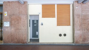 A building entrance with a door, a wall-mounted intercom, and a fire alarm panel. - Caduti di Via Fani by Wonderful Italy (Bologna)