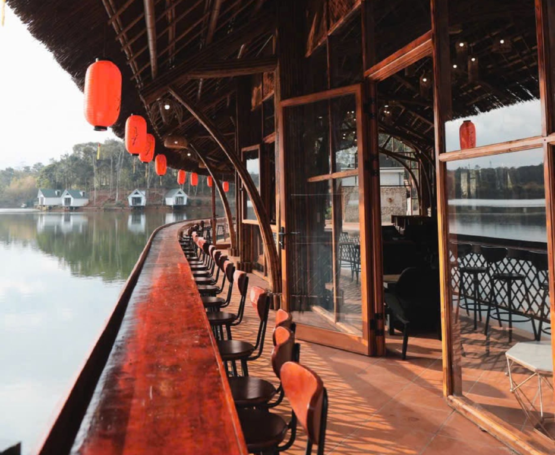Un bar con vistas a un lago y edificios al fondo.