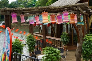 A wooden deck with a railing, potted plants, and a sign indicating ordering food.