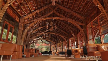 Un intérieur spacieux avec un haut plafond en bois en forme d’arc et de grandes fenêtres.