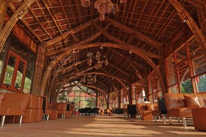 A spacious interior with a high, arched wooden ceiling and large windows.