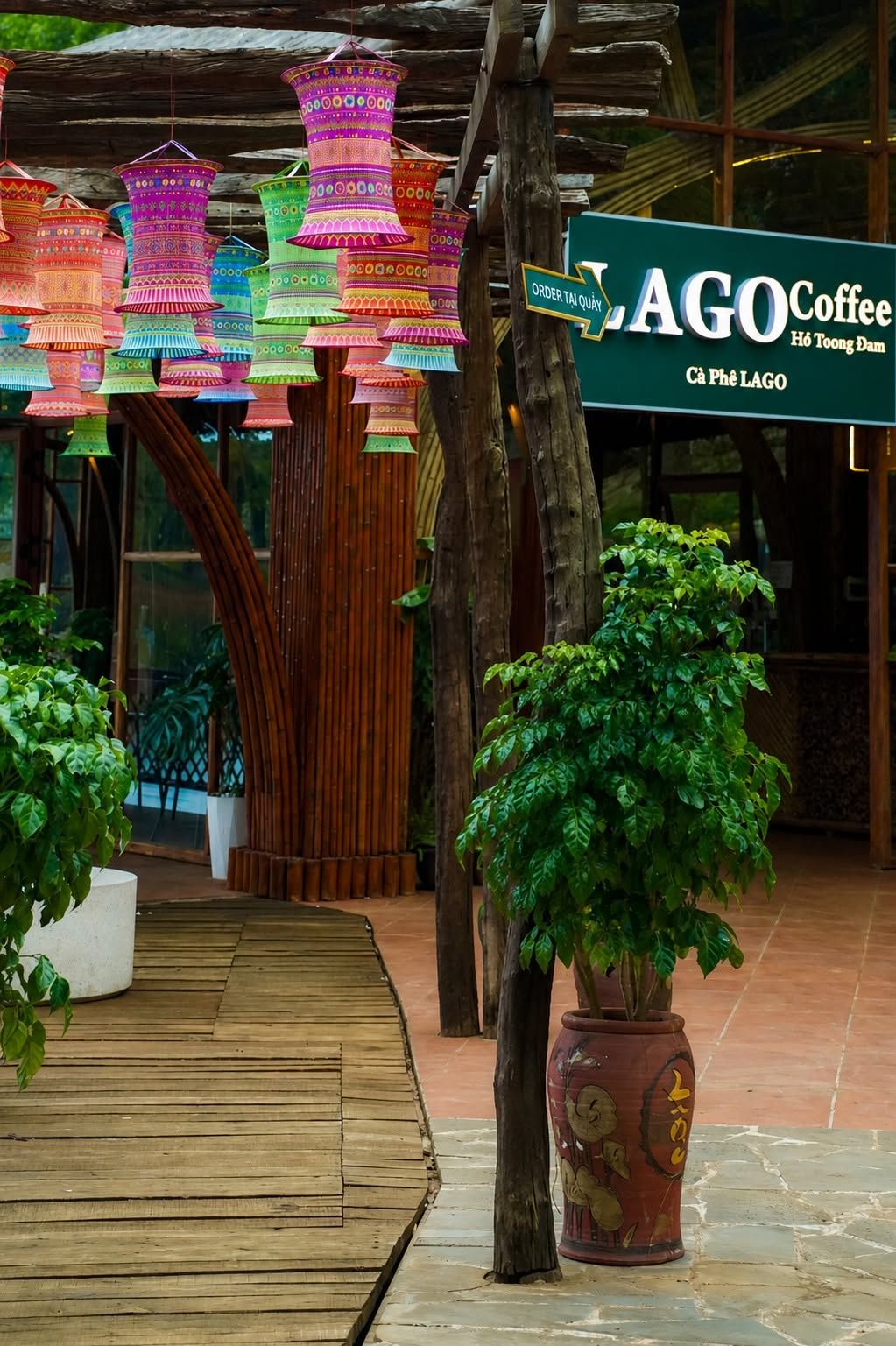 Uma passarela de madeira leva a um edifício com a placa LAGO Coffee.