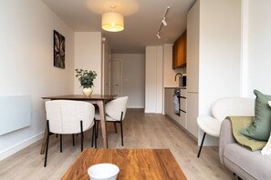 Un apartamento moderno con comedor, kitchenette y sala de estar.