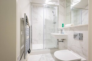 A modern bathroom with a glass-enclosed shower, a white sink, and a toilet. - Birmingham City Retreat No 41 (Birmingham)