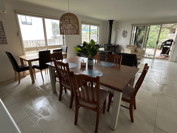 A dining area with a wooden table, chairs, and a hanging light fixture.