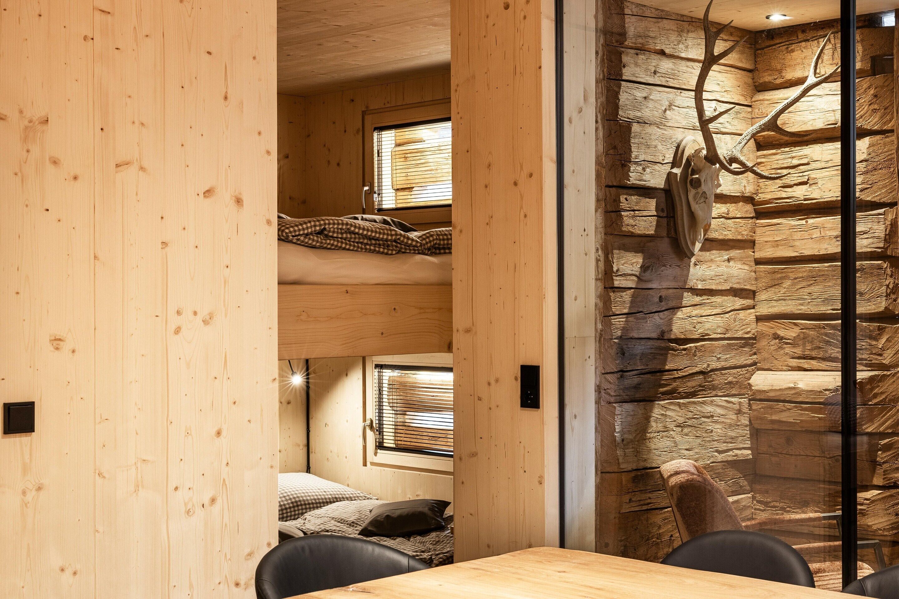 Un intérieur en bois avec un mur en pierre et une grande décoration en forme de bois de cerf.