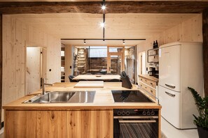 Eine moderne Küche mit Holzwänden, einem eingebauten Herd und einem Kühlschrank.
