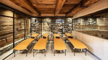 A room with wooden beams, stone walls, and a stone waterfall feature.
