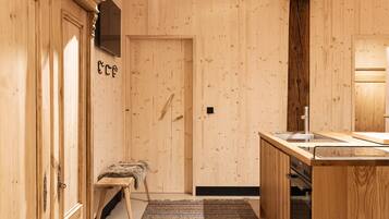 Un interior de madera con un banco, un lavamanos y una estufa.