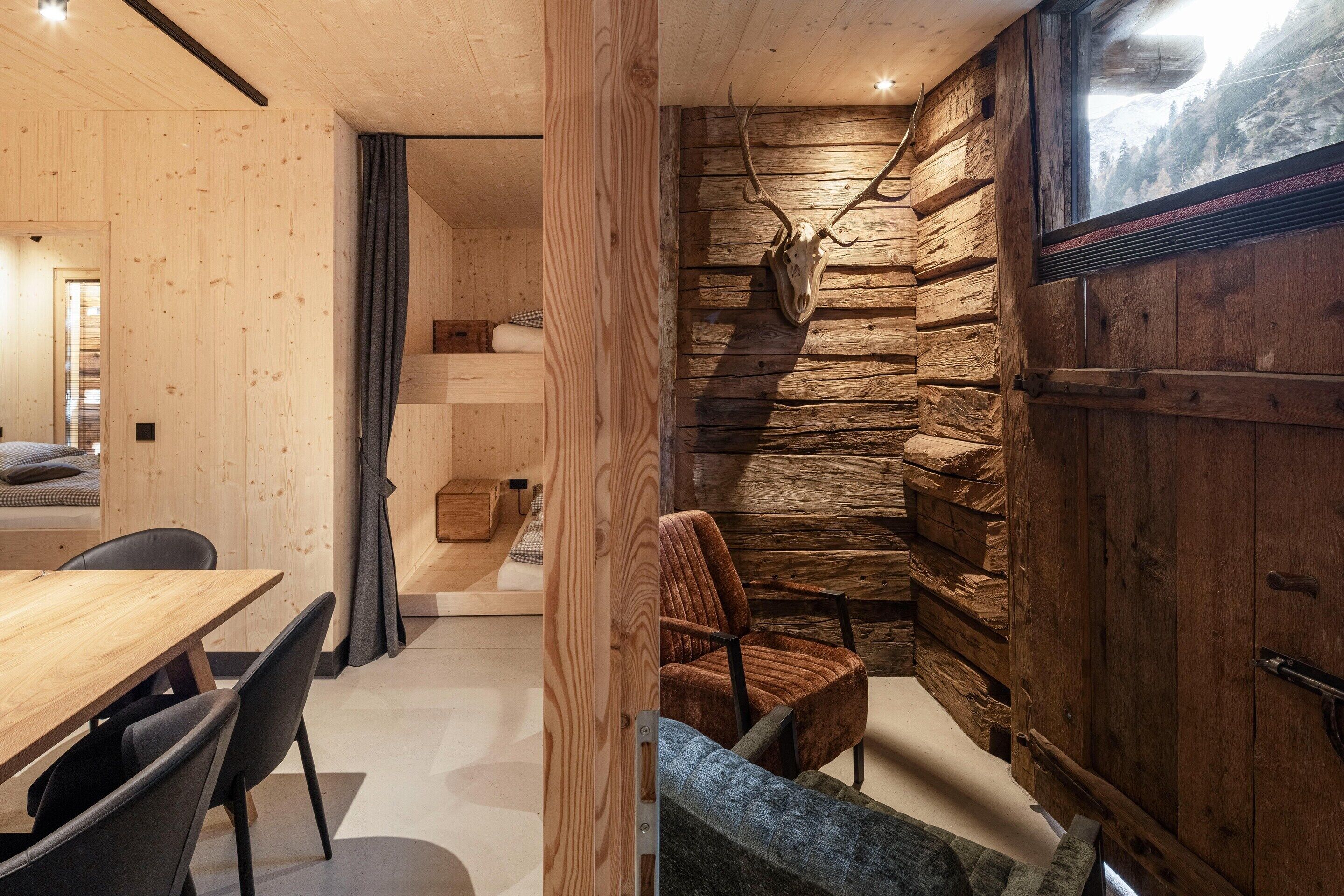 Un interior moderno con una zona de comedor de madera, un espacio de estar acogedor y una pared de piedra.