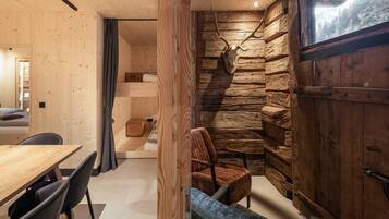 Un interior moderno con una zona de comedor de madera, un espacio de estar acogedor y una pared de piedra.