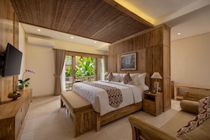 Un dormitorio con una cama grande, televisión, un escritorio de madera y un banco.