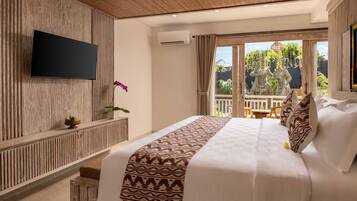 A hotel room with a bed, a flat-screen TV, a small potted plant, and a view of the outdoors.