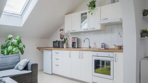 A modern kitchen with white cabinets, a built-in oven, and a window above the sink.