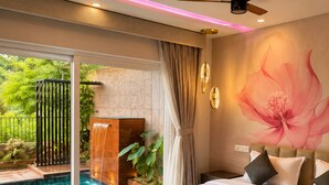 A modern bedroom with a large bed, a ceiling fan, and a view of a swimming pool. - Foggy Woods Resort Wayanad (Vythiri)
