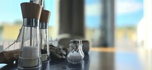 A clear glass salt shaker and a pepper shaker on a table with a blurred background. - The Ultimate Vacation: Your Modern 4-Star Coastal Oasis Near the Forest in Graal-Müritz for ma (Graal-Müritz)