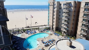 Ein Hotel mit Poolbereich, Blick auf den Strand und einer Flagge.