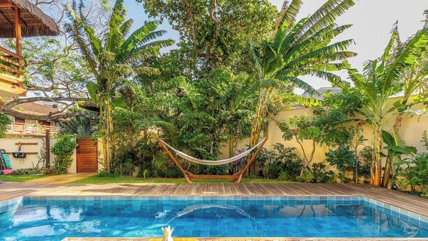 A swimming pool with a hammock, wooden deck, and tropical vegetation. - Honeymoon suite with a private rooftop Jacuzzi (Jijoca de Jericoacoara)