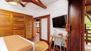 A room with a bed, a desk with a chair, a television, and wooden doors. - Honeymoon suite with a private rooftop Jacuzzi (Jijoca de Jericoacoara)