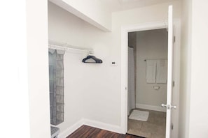 A bathroom with a shower, a towel rack, and a toilet.
