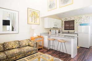 A compact living space with a kitchenette, a sofa, and a dining area. - Cozy Jasmine Cottage | Savannah + Tybee l Cohens Retreat (Savannah)