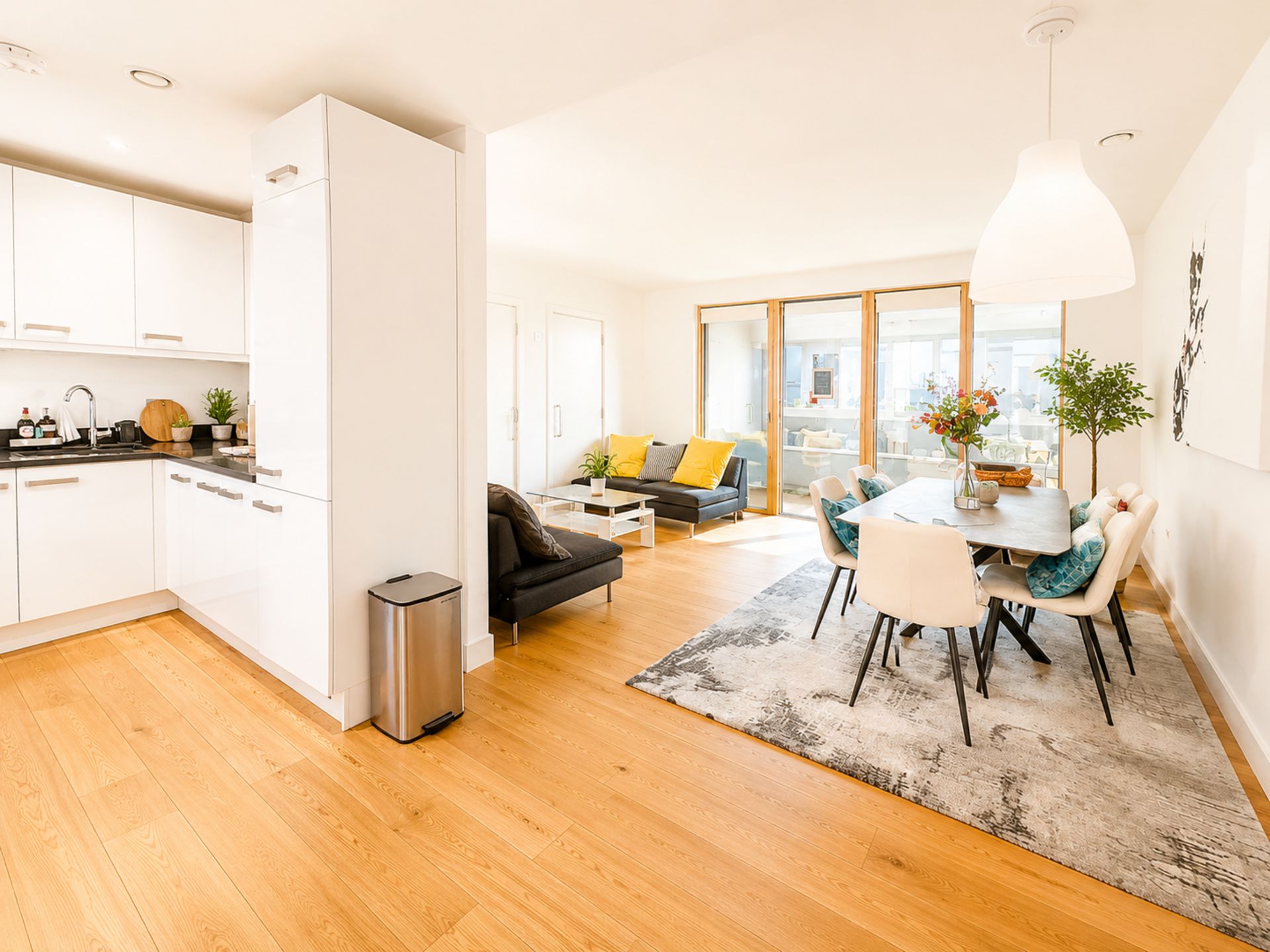 Un appartement moderne comprenant une cuisine, un coin repas et un salon.
