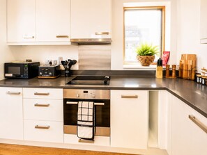 A modern kitchen with a built-in oven, microwave, and toaster. - Spacious 3BDR Haven in the Heart of East London (Greater London)