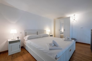 A neatly arranged bedroom with a single bed, bedside tables with lamps, a wardrobe, and a mirror. - Caduti di Via Fani by Wonderful Italy (Bologna)