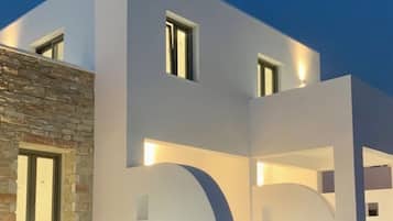 A modern two-story building with a flat roof and a stone facade on one side.