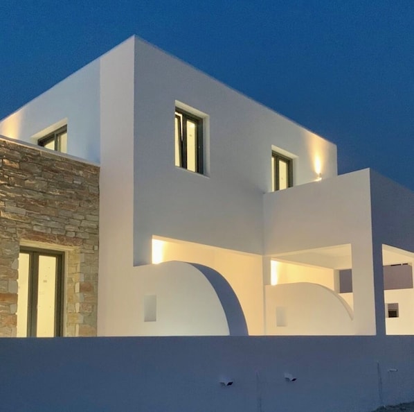 Un bâtiment moderne à deux étages, doté d’un toit plat et d’une façade en pierre sur un de ses côtés.