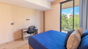 Ein Hotelzimmer mit Bett, Schreibtisch und Blick ins Freie.