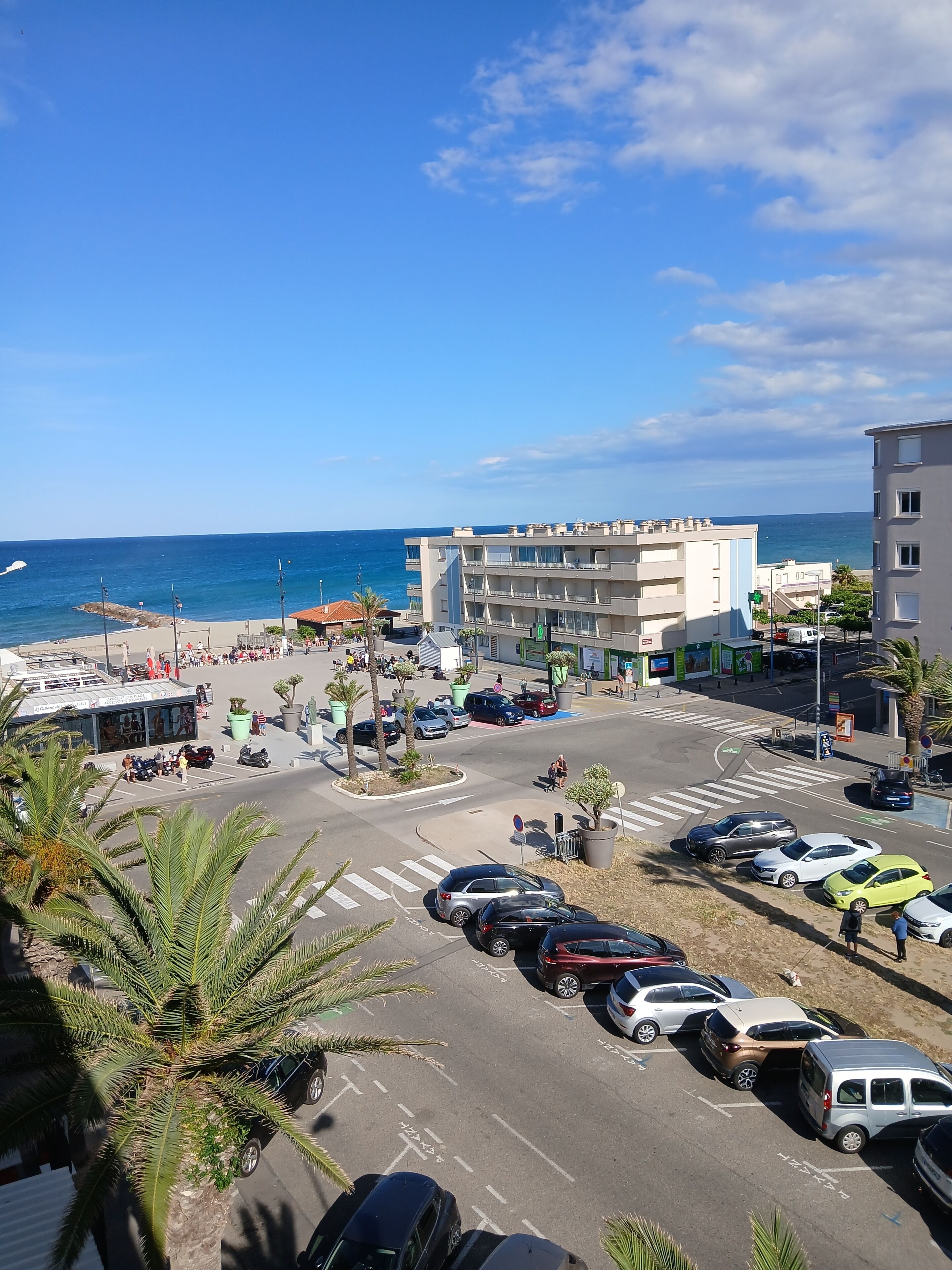 Zona costera urbana con un estacionamiento, edificios y vistas al mar.