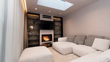 Una sala moderna con chimenea, un sofá seccional y una pared de acento de piedra.