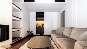 A modern living room with a sofa, a coffee table, and a fireplace.