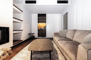 A modern living room with a sofa, a coffee table, and a fireplace. - Villa Rossa Luxury & SPA Residence  (Asenovgrad)