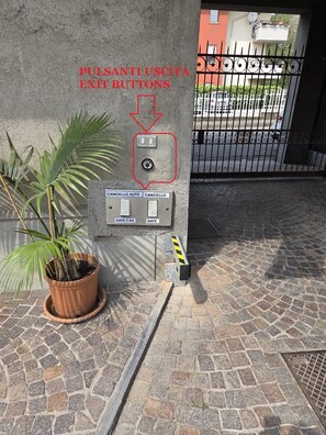 A wall-mounted control panel with buttons labeled 'CANCELLO AUTO,' 'CANCELLO,' 'GATE CAR,' and 'GATE,' indicating a parking or gate system. - Malpensa Sleep & Go Deluxe Naples (Somma Lombardo)