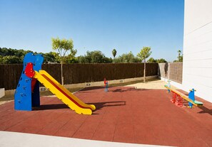 A playground with a slide and climbing structures, surrounded by a fenced area. - La Haya Penthouse Javea Arenal (Javea)