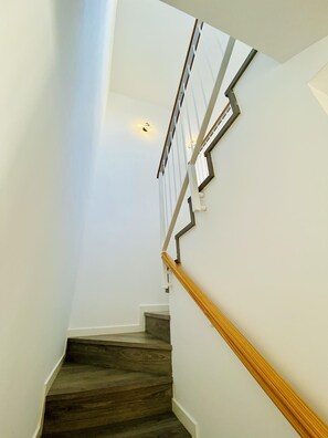 Eine Treppe mit Holzdielen und weißen Wänden.
