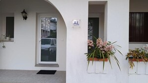 A white building with a door, a sign with the letter 'AL', and flower planters on the right. - Discover the perfect getaway in the heart of Vouzela and feel the rhythm of nature! (Vouzela)