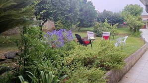 A garden with various plants and a seating area with chairs and a table. - Discover the perfect getaway in the heart of Vouzela and feel the rhythm of nature! (Vouzela)