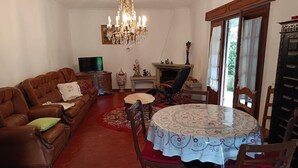 A living room with a sofa set, a television, a fireplace, and a dining table. - Discover the perfect getaway in the heart of Vouzela and feel the rhythm of nature! (Vouzela)