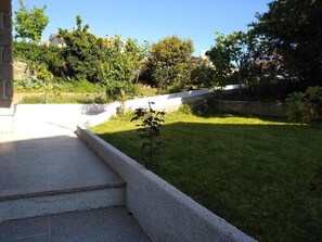 A paved pathway leading to a grassy area with a small plant in the foreground. - Discover the perfect getaway in the heart of Vouzela and feel the rhythm of nature! (Vouzela)
